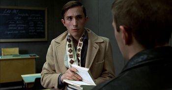 Movie still from “Evil” (2003), directed by Mikael Håfström – A young man holding a book in front of a mirror; Close Up shot, Over the shoulder angle