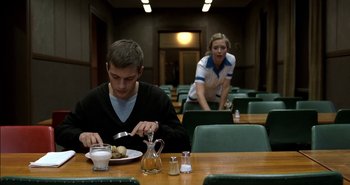 Movie still from “Evil” (2003), directed by Mikael Håfström – A man and a woman sitting at a table eating food; Medium shot, Over the shoulder angle