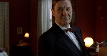 Movie still from “Evil” (2003), directed by Mikael Håfström – An older man in a suit and bow tie; Close Up shot, Low angle