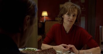 Movie still from “Evil” (2003), directed by Mikael Håfström – A woman sitting at a table with a plate of food in front of her; Close Up shot, Over the shoulder angle