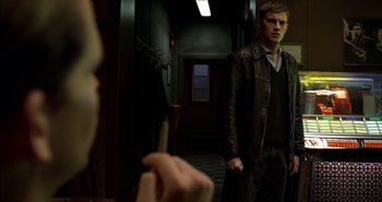Movie still from “Evil” (2003), directed by Mikael Håfström – A man in a leather jacket standing in front of a mirror; Medium shot, Over the shoulder angle