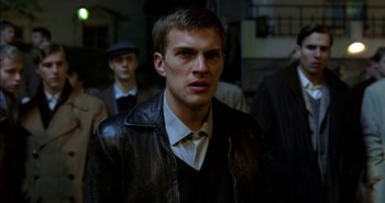 Movie still from “Evil” (2003), directed by Mikael Håfström – A man in a leather jacket and a hat; Close Up shot, Low angle