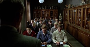 Movie still from “Evil” (2003), directed by Mikael Håfström – A group of young men sitting at a table; Wide shot, High angle