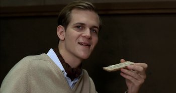 Movie still from “Evil” (2003), directed by Mikael Håfström – A young man holding a piece of food in his hand; Close Up shot, Low angle