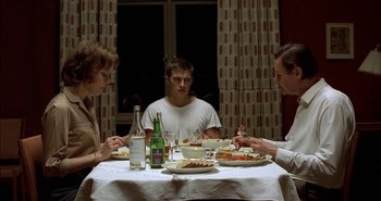 Movie still from “Evil” (2003), directed by Mikael Håfström – A group of people sitting at a table with plates of food; Medium shot, High angle