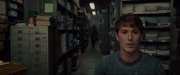 Movie still from “Glass” (2019), directed by M. Night Shyamalan – A young man is standing in a warehouse; Close Up shot, Over the shoulder angle