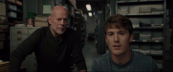 Movie still from “Glass” (2019), directed by M. Night Shyamalan – A man standing next to a man sitting next to him; Close Up shot, Over the shoulder angle