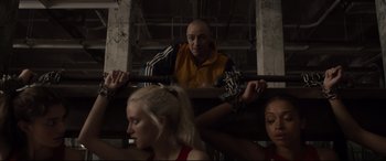 Movie still from “Glass” (2019), directed by M. Night Shyamalan – A group of people sitting in a room; Medium shot, Low angle