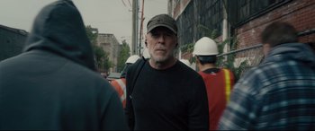 Movie still from “Glass” (2019), directed by M. Night Shyamalan – An older man wearing a hat is walking down the street; Close Up shot, Over the shoulder angle