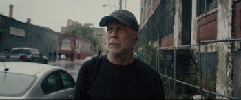 Movie still from “Glass” (2019), directed by M. Night Shyamalan – A man wearing a hat and ear buds on his ears; Close Up shot, Low angle