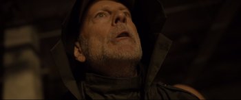 Movie still from “Glass” (2019), directed by M. Night Shyamalan – An older man wearing a hat and a jacket; Close Up shot, Low angle