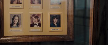 Movie still from “Glass” (2019), directed by M. Night Shyamalan – A picture of some people hanging on a wall; Extreme Close Up shot, High angle