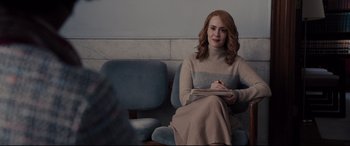 Movie still from “Glass” (2019), directed by M. Night Shyamalan – A woman sitting in a chair writing on a piece of paper; Medium shot, Over the shoulder angle
