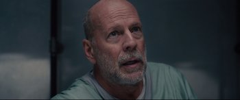 Movie still from “Glass” (2019), directed by M. Night Shyamalan – An older man with a beard looking upward; Close Up shot, Low angle