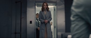 Movie still from “Glass” (2019), directed by M. Night Shyamalan – A woman standing in an elevator wearing a coat; Medium shot, Low angle