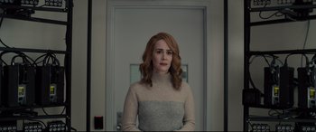 Movie still from “Glass” (2019), directed by M. Night Shyamalan – A woman with red hair standing in front of a door; Medium shot, Low angle