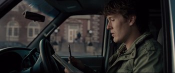 Movie still from “Glass” (2019), directed by M. Night Shyamalan – A man sitting in a car looking at his cell phone; Close Up shot, Over the shoulder angle