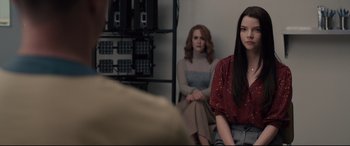 Movie still from “Glass” (2019), directed by M. Night Shyamalan – Two women are sitting in a room and one of them is wearing a red shirt; Medium shot, Over the shoulder angle