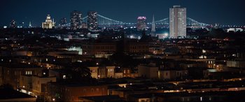 Movie still from “Glass” (2019), directed by M. Night Shyamalan – A view of a city at night with a bridge in the background; Extreme Wide shot, High angle