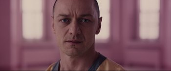 Movie still from “Glass” (2019), directed by M. Night Shyamalan – A man's face in front of a pink wall; Close Up shot, Over the shoulder angle