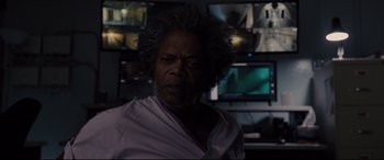 Movie still from “Glass” (2019), directed by M. Night Shyamalan – An older man is looking into the camera; Close Up shot, Over the shoulder angle