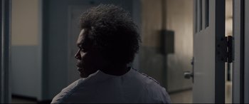 Movie still from “Glass” (2019), directed by M. Night Shyamalan – A person with a white shirt is looking into the distance; Close Up shot, Over the shoulder angle