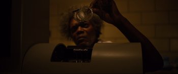 Movie still from “Glass” (2019), directed by M. Night Shyamalan – A man holding a pair of handcuffs in front of his face; Close Up shot, Low angle