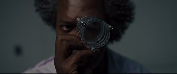 Movie still from “Glass” (2019), directed by M. Night Shyamalan – A man holding a camera with a reflection of himself in the mirror; Extreme Close Up shot, Overhead angle