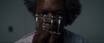 Movie still from “Glass” (2019), directed by M. Night Shyamalan – A person holding a metal cage; Extreme Close Up shot, Low angle
