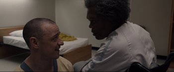 Movie still from “Glass” (2019), directed by M. Night Shyamalan – A man and a woman talking to each other in a room; Close Up shot, Over the shoulder angle