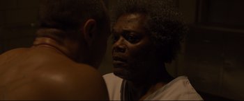 Movie still from “Glass” (2019), directed by M. Night Shyamalan – An older man looking into a mirror while a younger man looks at him; Close Up shot, Over the shoulder angle