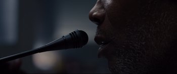 Movie still from “Glass” (2019), directed by M. Night Shyamalan – A man's face with a microphone in his mouth; Extreme Close Up shot, Low angle