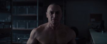 Movie still from “Glass” (2019), directed by M. Night Shyamalan – A man with no shirt is standing in a room; Close Up shot, Low angle