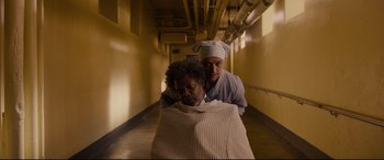 Movie still from “Glass” (2019), directed by M. Night Shyamalan – A man and a woman are in a hospital hallway; Medium shot, High angle