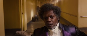Movie still from “Glass” (2019), directed by M. Night Shyamalan – A person wearing a suit and tie; Close Up shot, Low angle