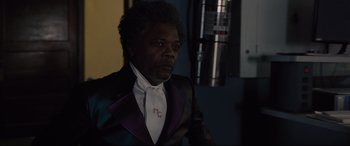 Movie still from “Glass” (2019), directed by M. Night Shyamalan – A man in a suit and tie looking at the camera; Close Up shot, Over the shoulder angle