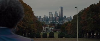 Movie still from “Glass” (2019), directed by M. Night Shyamalan – A view of a city skyline from a park; Extreme Wide shot, High angle