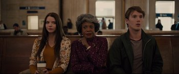 Movie still from “Glass” (2019), directed by M. Night Shyamalan – Three people sitting on a bench in front of a window; Medium shot, Over the shoulder angle
