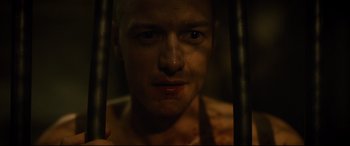 Movie still from “Glass” (2019), directed by M. Night Shyamalan – A person in a dark room; Close Up shot, Over the shoulder angle