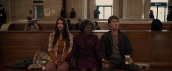 Movie still from “Glass” (2019), directed by M. Night Shyamalan – A group of people sitting on a bench in front of a window; Medium shot, High angle