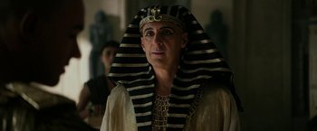 Movie still from “Exodus: Gods and Kings” (2014), directed by Ridley Scott – A man wearing a pharaoh's costume and a gold crown; Close Up shot, Low angle