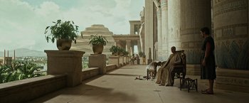 Movie still from “Exodus: Gods and Kings” (2014), directed by Ridley Scott – An old man sitting on a bench in front of a building; Extreme Wide shot, Low angle