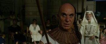Movie still from “Exodus: Gods and Kings” (2014), directed by Ridley Scott – An old man with an angry look on his face holding a spear; Close Up shot, Over the shoulder angle