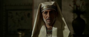 Movie still from “Exodus: Gods and Kings” (2014), directed by Ridley Scott – An older man wearing a white headdress and a white robe; Close Up shot, Over the shoulder angle
