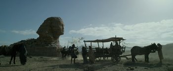 Movie still from “Exodus: Gods and Kings” (2014), directed by Ridley Scott – A group of people standing next to a statue of a person; Extreme Wide shot, Low angle