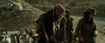 Movie still from “Exodus: Gods and Kings” (2014), directed by Ridley Scott – A man with a beard holding a wooden stick and another man with a beard holding a wooden stick; Medium shot, Low angle
