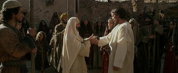 Movie still from “Exodus: Gods and Kings” (2014), directed by Ridley Scott – A man and a woman shaking hands in front of a group of people; Wide shot, Over the shoulder angle