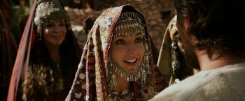 Movie still from “Exodus: Gods and Kings” (2014), directed by Ridley Scott – A woman in a headdress smiles for the camera; Close Up shot, Over the shoulder angle