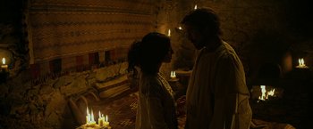 Movie still from “Exodus: Gods and Kings” (2014), directed by Ridley Scott – A man and a woman standing next to lit candles; Medium shot, Over the shoulder angle