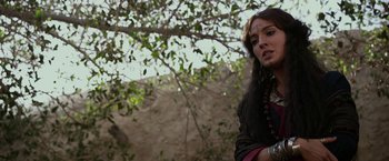 Movie still from “Exodus: Gods and Kings” (2014), directed by Ridley Scott – A woman with a face tattoo standing in front of a tree; Close Up shot, Over the shoulder angle